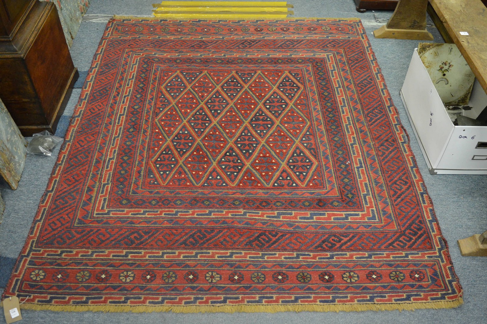 An unusual Persian style carpet, red ground with geometric decoration 182cm x 153cm.