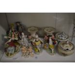 A collection of decorative Dresden figurines and a pair of candlesticks.