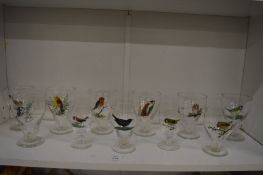 An unusual set of drinking glasses, each enamel decorated with various birds.