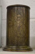 An Islamic engraved brass cylindrical vessel.