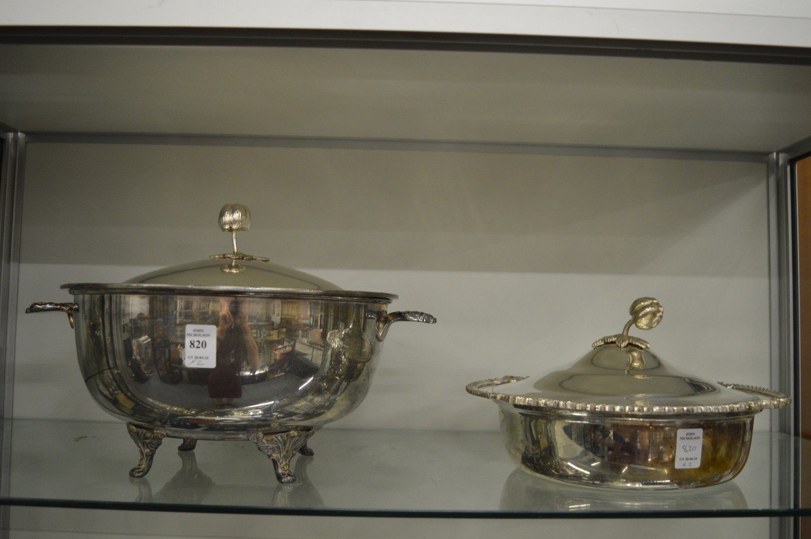 Two large plated serving dishes with lids.