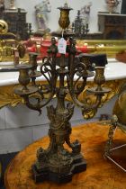 A large pair of decorative cast metal four branch, five light candelabra.