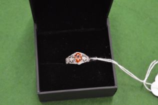An 18ct white gold, diamond and orange sapphire ring, size N.