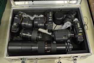 Aluminium camera case containing three Canon camera bodies and numerous lenses.