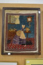 An unusual wool work picture depicting an interior scene with a lady wearing a bonnet.