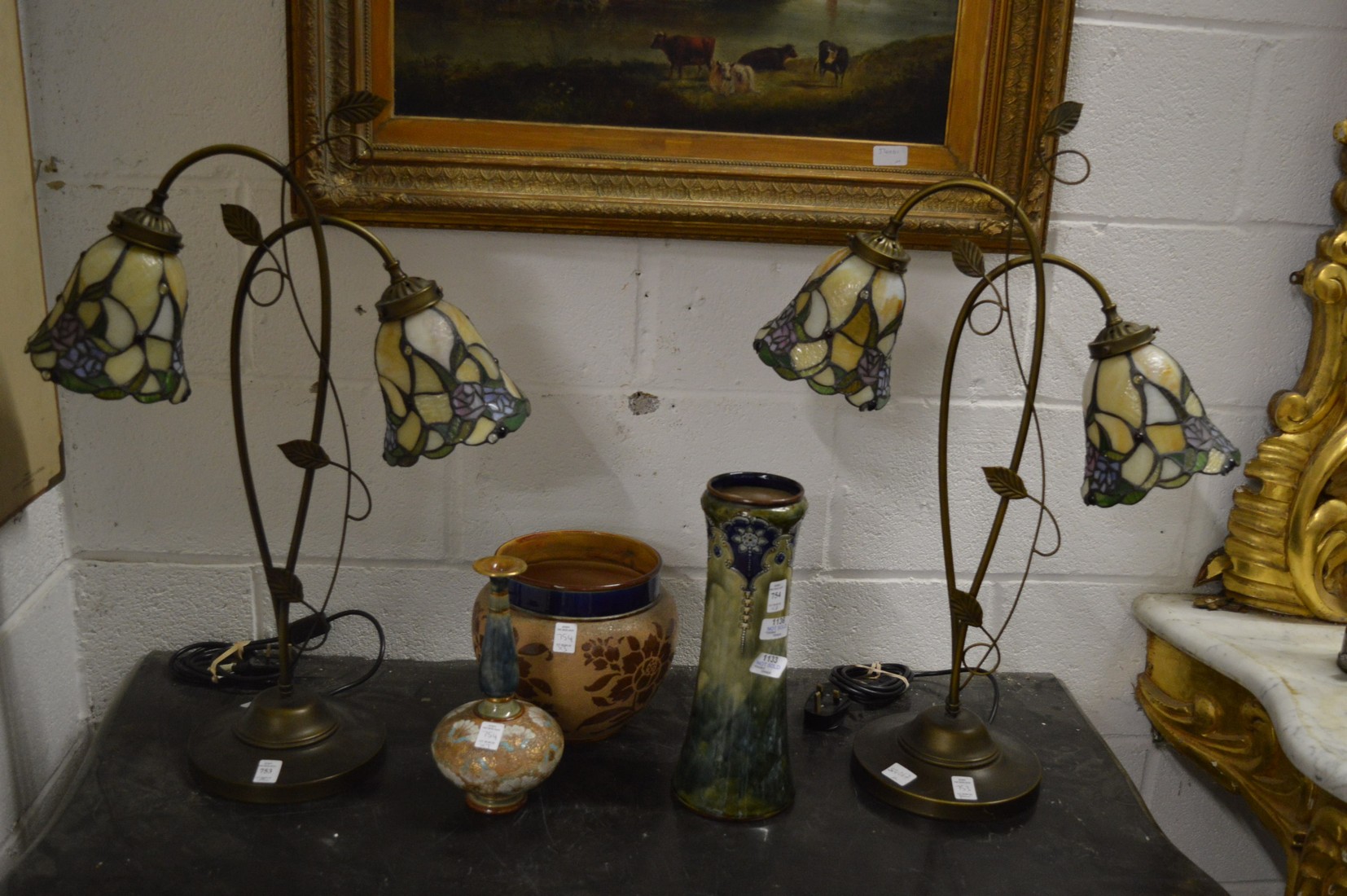 A pair of Art Nouveau style twin branch table lamps with stain glass shades.