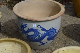 A large glazed planter decorated with a dragon.