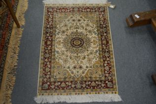 A small Persian style part silk rug, cream ground with floral decoration 93cm x 62cm.