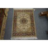 A small Persian style part silk rug, cream ground with floral decoration 93cm x 62cm.