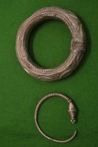 An Eastern white metal bangle and another.