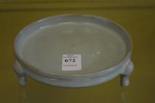 A Chinese celadon glazed circular brush washer or censer on three feet.