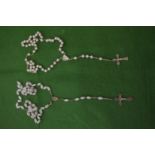 Two rosary necklaces with pearls and white beads.