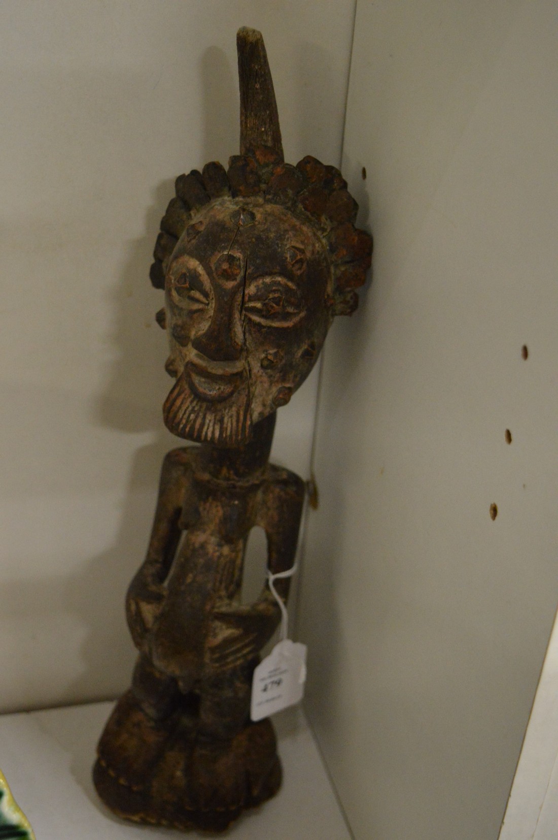 A carved wood African figure of a standing male.