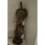 A carved wood African figure of a standing male.