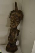 A carved wood African figure of a standing male.