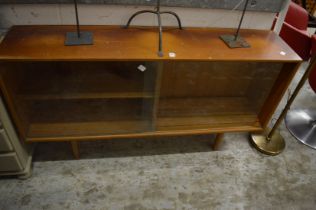 A bookcase with glass sliding doors.