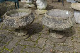 A pair of reconstituted stone pedestal planters.