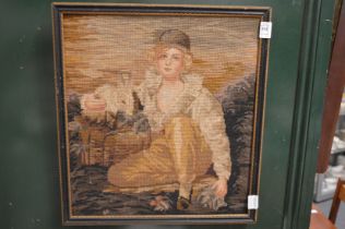 A wool work picture depicting a seated boy with a rabbit.