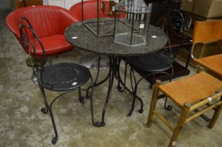 A small granite topped circular table with wrought iron base and pair of chairs.