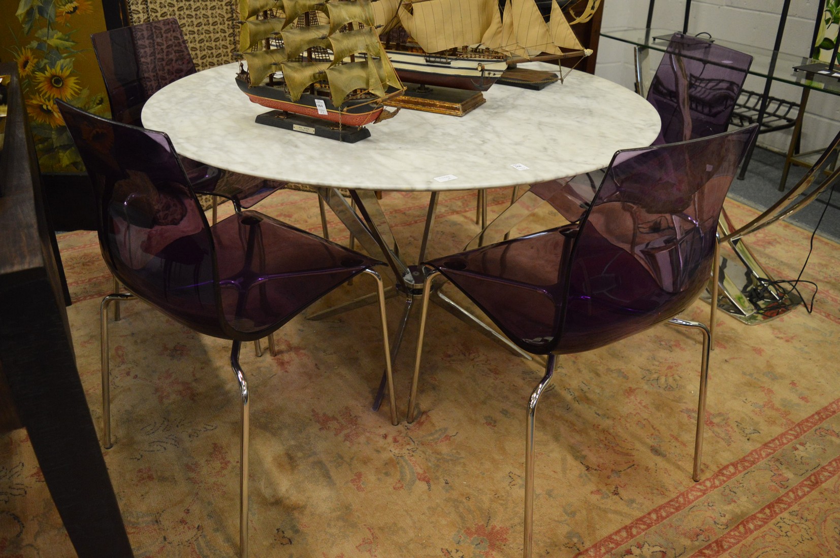 A marble circular dining table with chrome supports together with a set of five chrome framed and