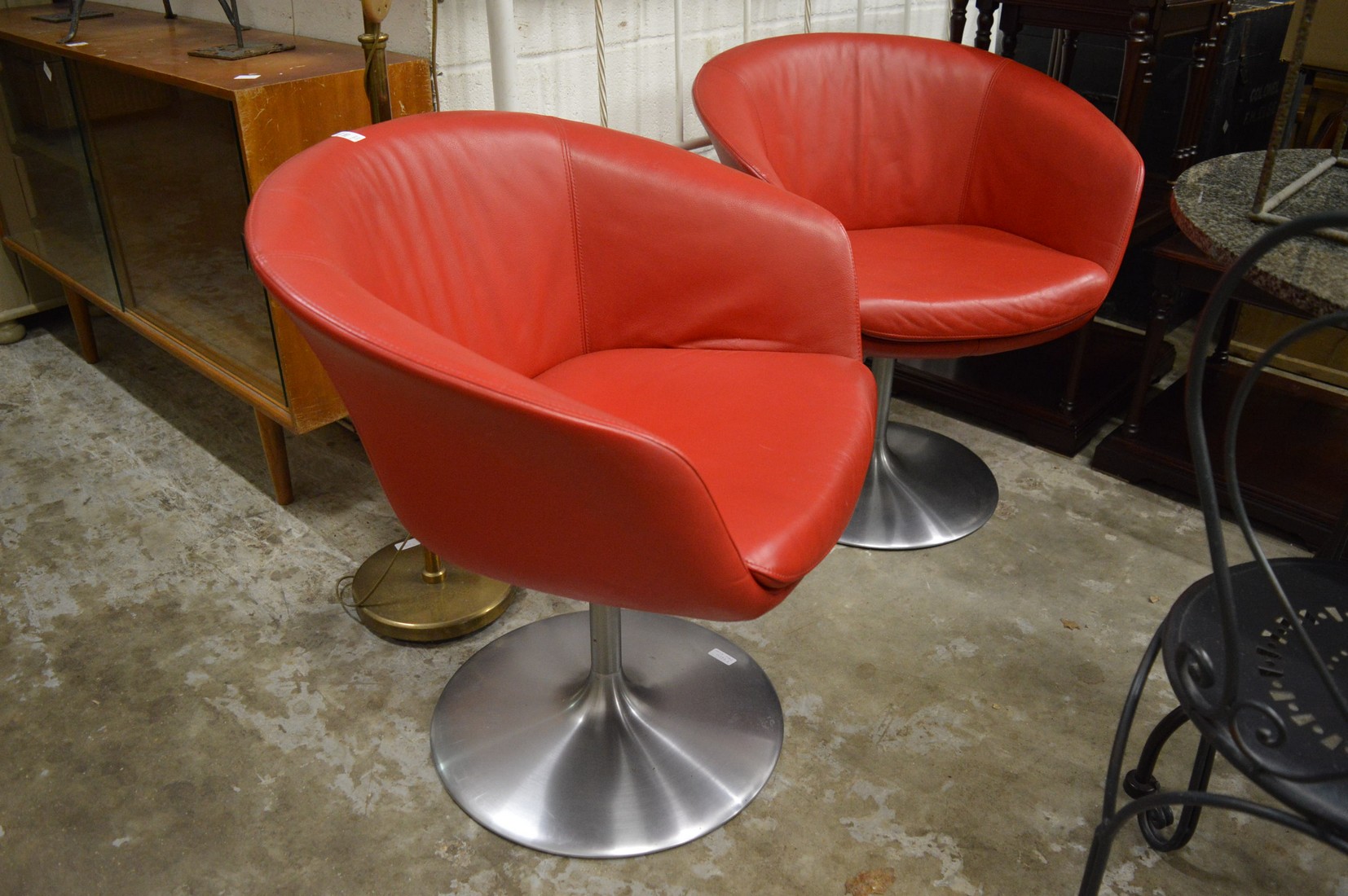 A pair of Walter Knoll stylish red leather and brushed steel swivel chairs.