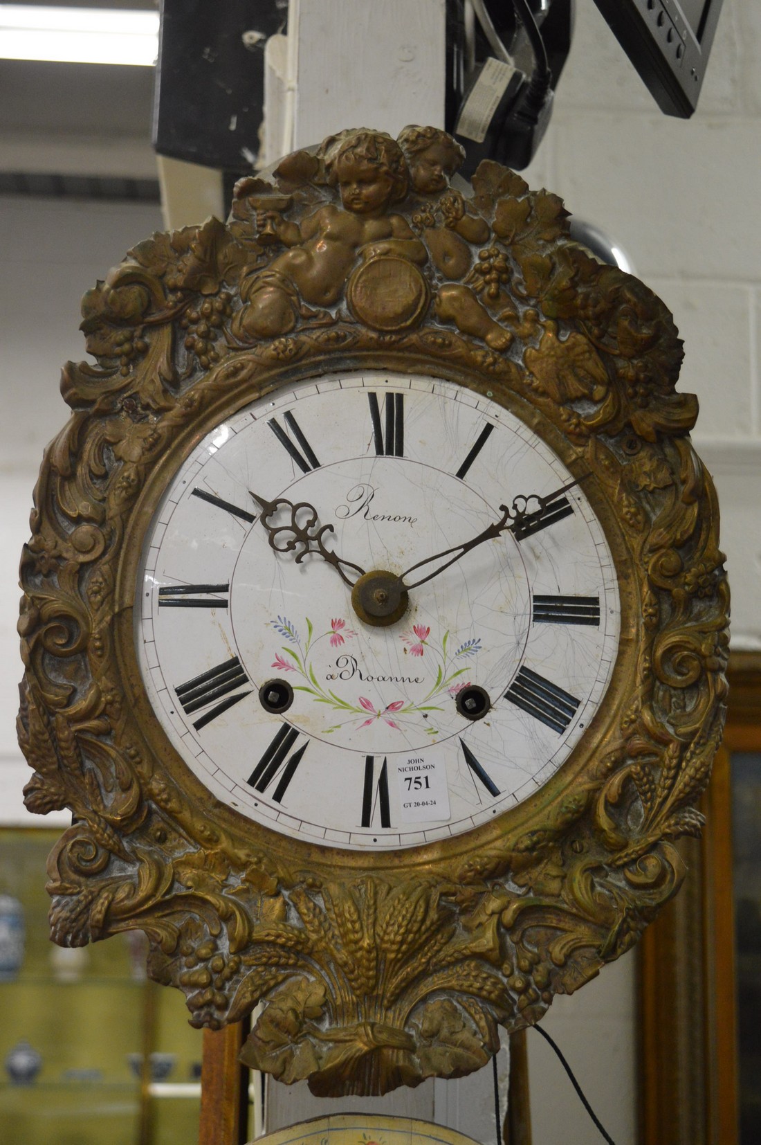 A Continental wall clock with painted enamel dial and embossed brass frame.