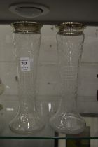 A pair of cut glass vases with silver rims.