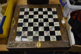 Decorative chess board with chess pieces and various other items.