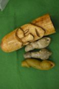 A carved bone pictorial phallic together with three stone phalli.