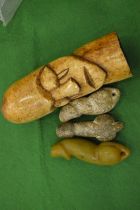 A carved bone pictorial phallic together with three stone phalli.