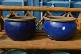 A large pair of turquoise glazed planters.