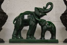 C H Lemancea, a pottery model of an elephant and calf with green lustre glaze.