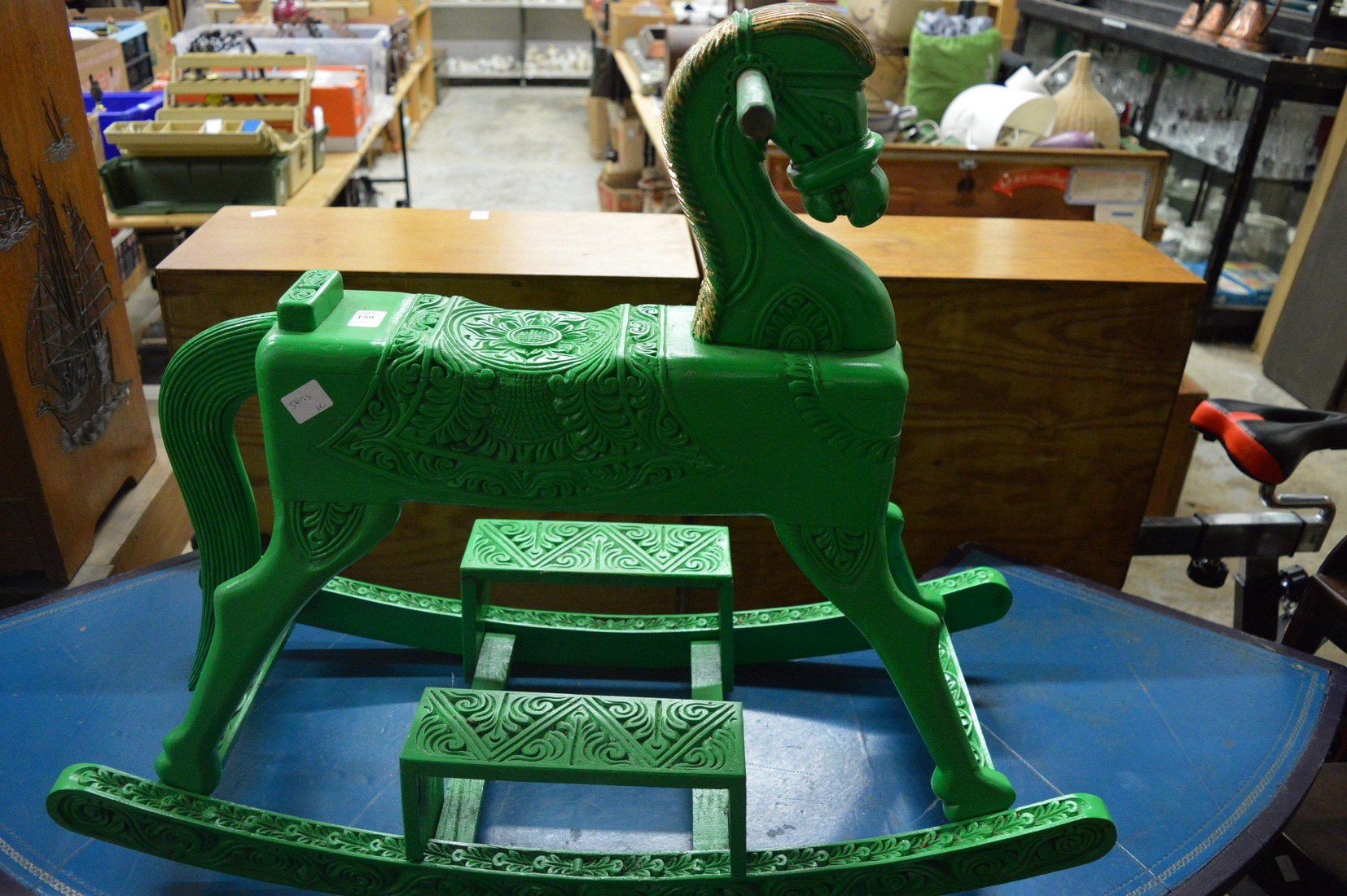 A green painted carved wood rocking horse.