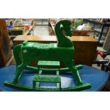 A green painted carved wood rocking horse.