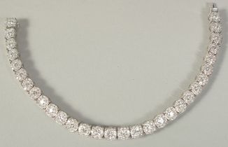 A SUPERB 18 CARAT WHITE GOLD ILLUSION SET DIAMOND LINE BRACELET with 30 cluster set diamonds. 20cm