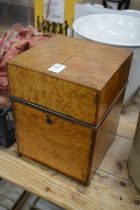 A burr wood decanter box containing a set of four cut glass decanters.