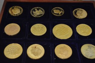 A quantity of gilt metal Commemorative coins in a fitted case.