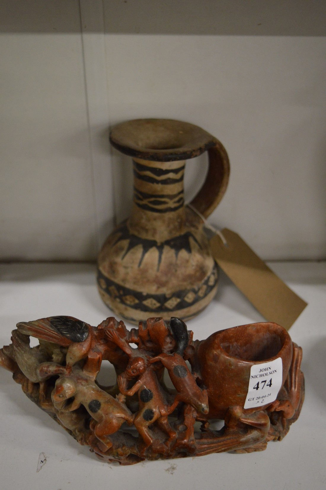 A Chinese carved soapstone group and an early Islamic pottery vessel.