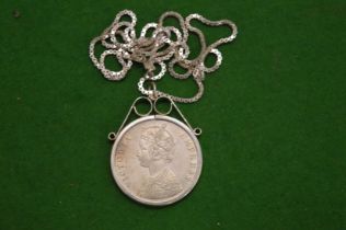 A silver chain with Victorian coin inset pendant.