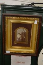 An early black and white photograph of husband and wife in a decorative gilt frame and glazed