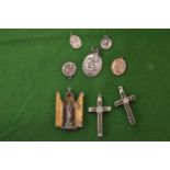 Religious pendants, a crucifix and a small devotional piece.