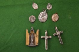 Religious pendants, a crucifix and a small devotional piece.