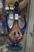 An Islamic blue glass ewer with enamelled portrait decoration.