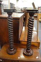 A pair of turned hardwood stands.