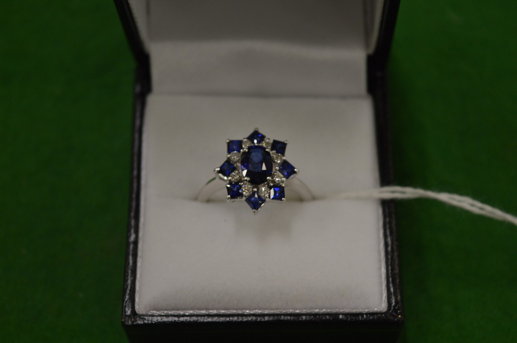 An 18ct white gold, diamond and sapphire cluster ring, size M½.