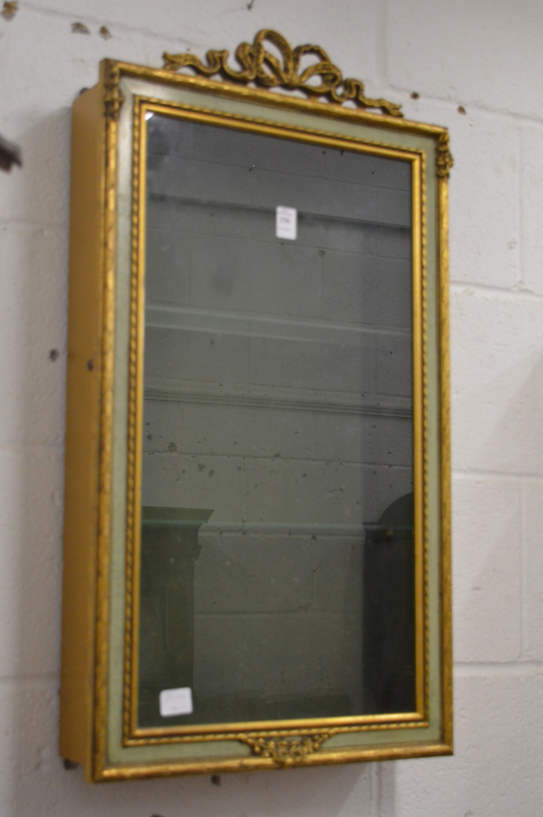 A decoratively painted and gilded hanging display cabinet.