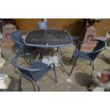 A patio dining set comprising table, four chairs and a parasol base.
