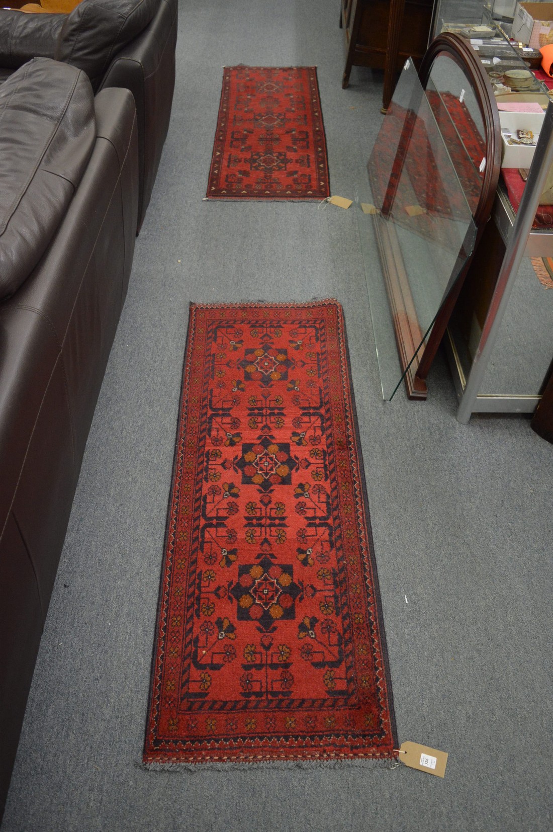 Two small Persian style red ground runners 146cm x 52cm and 153cm x 53cm.