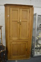 A large pine standing corner cupboard.