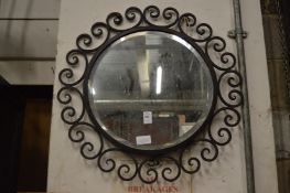 A circular wrought iron framed mirror.